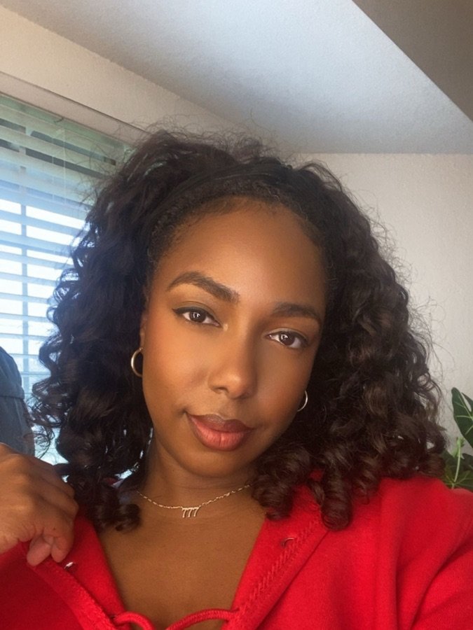 Shea &mdash; SoCal beauty and home creator, smiling in a red top with curled hair